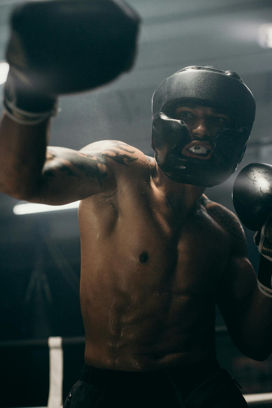 Boxer in a dark boxing ring with gloves 